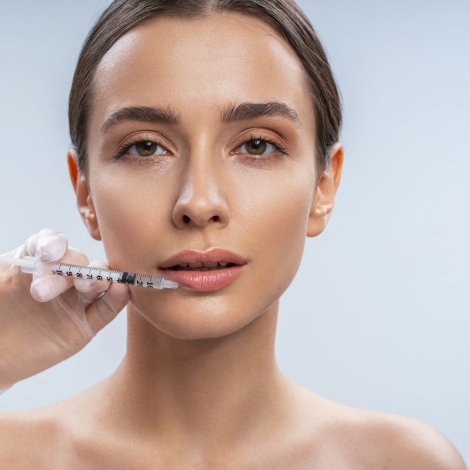 Cute girl looking forward while doing injection in her lips