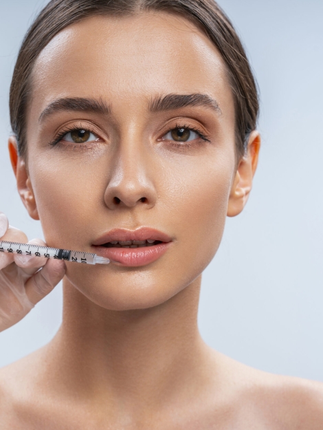 Cute girl looking forward while doing injection in her lips